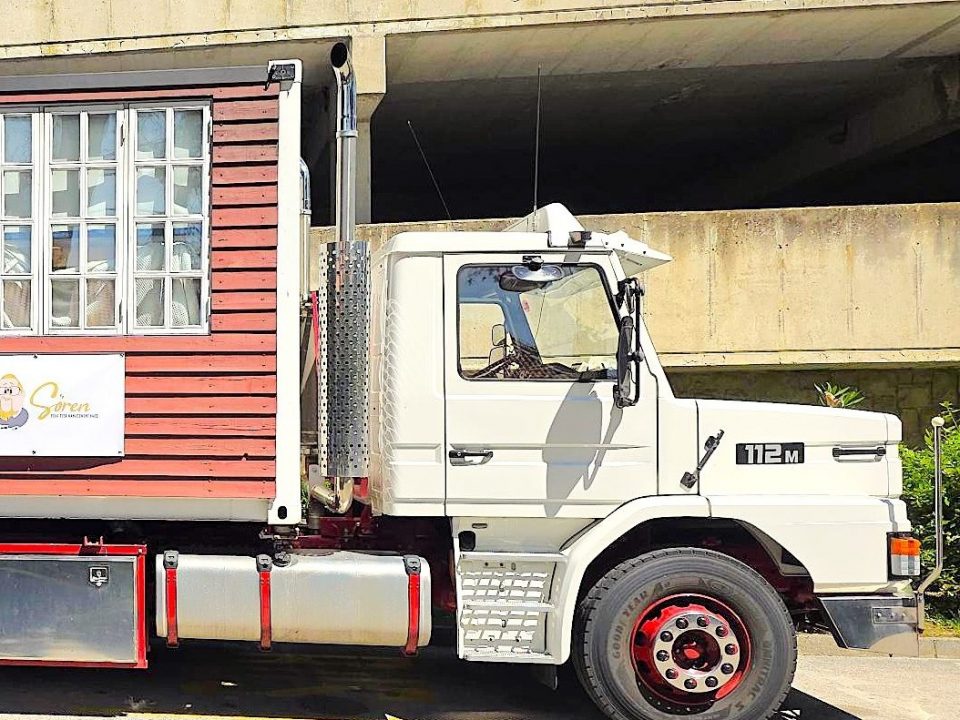 Der Truck von Sven Mahn IT steht im Umfeld der Dynamics Minds. Zu sehen ist ein Werbebanner am Truck und ein Mitarbeiter, der einen Kasten Jerboa-Getränke trägt.